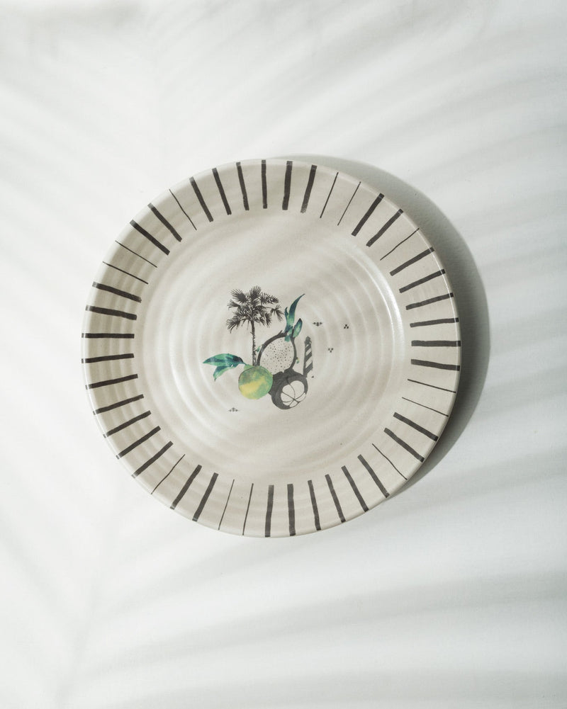 Ceylon Pasta Plate with a black striped rim and a palm tree and fruit motif.