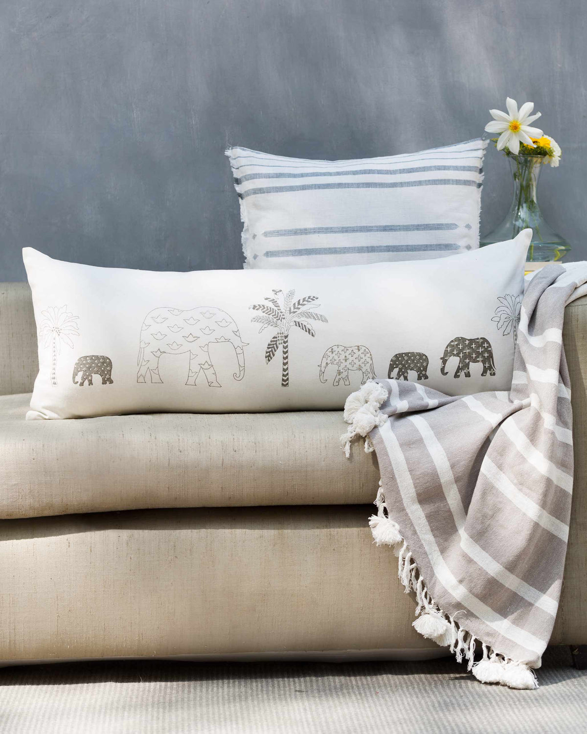 Ele Palm Pillow Cover on a sofa with grey elephants and palm trees.