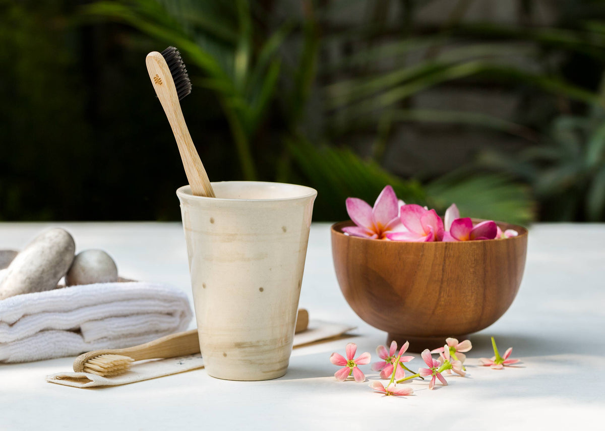 Bamboo Toothbrush standing in a ceramic cup.