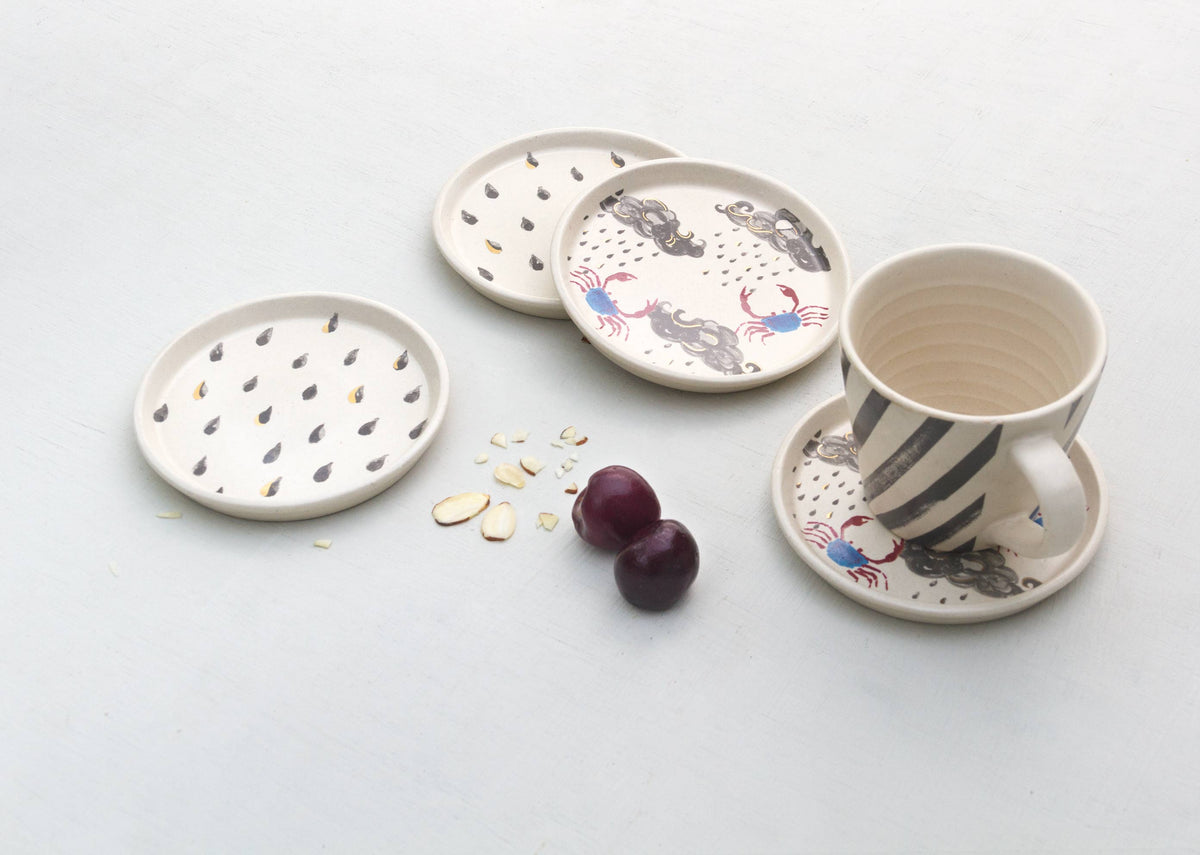 Crab Coaster Set beside a cup and saucer printed with crabs.