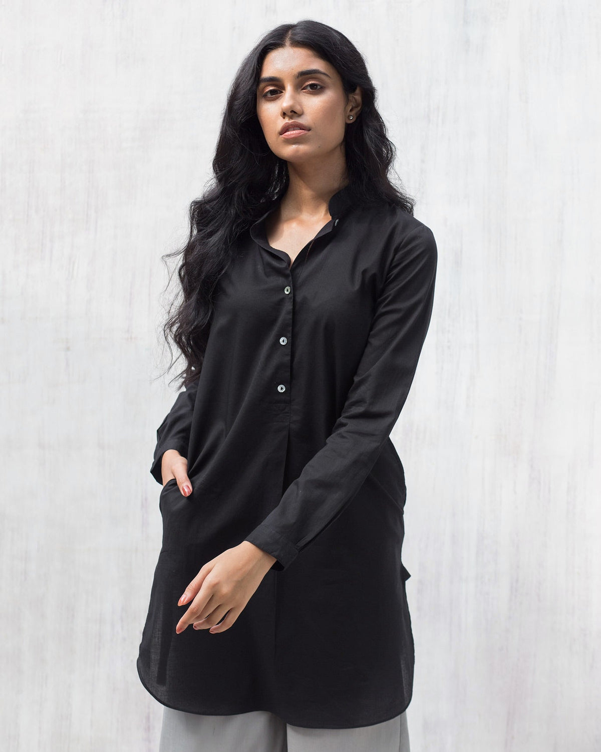 Person wearing a black Basic Mid Length Kurta with a band collar and buttoned placket.