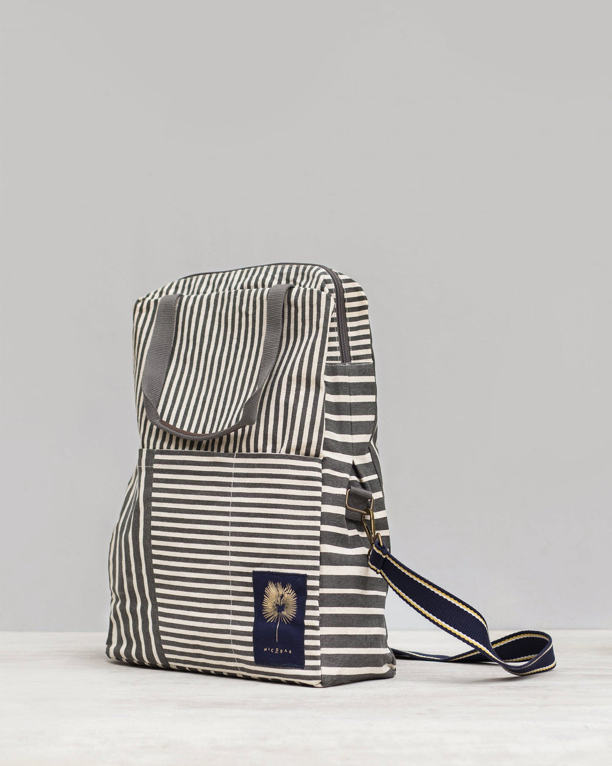 Side view of a Noto Artist's bag showing its navy and gold shoulder strap.
