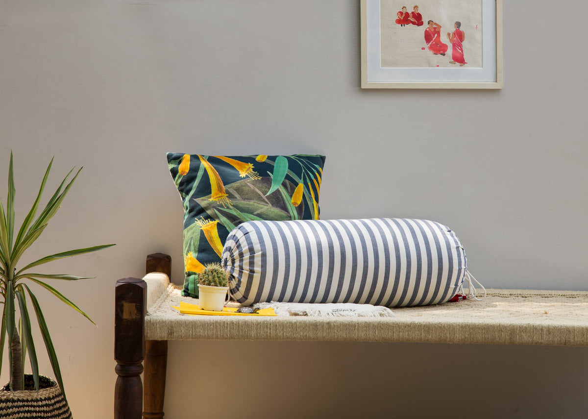 Ahasa Bolster Cover in blue and white stripes, styled on a bench.