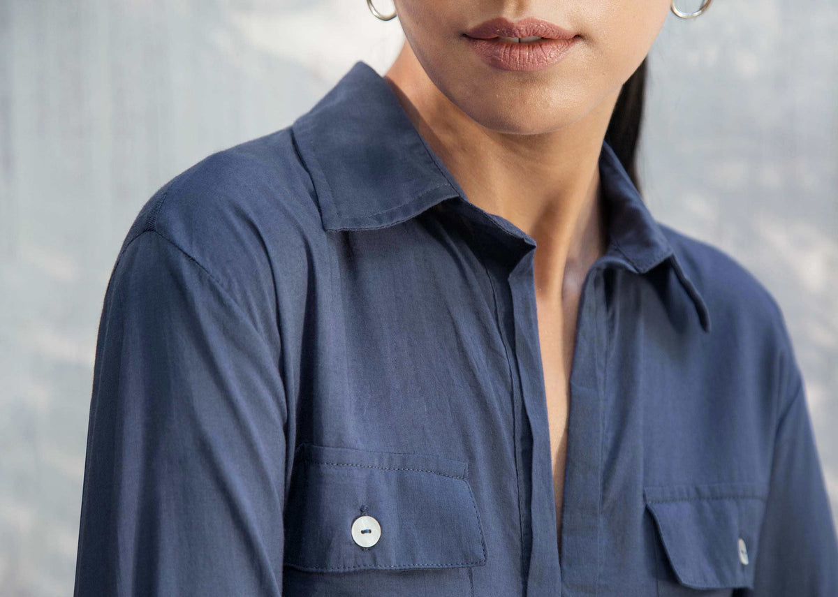 Close-up of an indigo Open Collar Top showing the open collar and a pocket button.