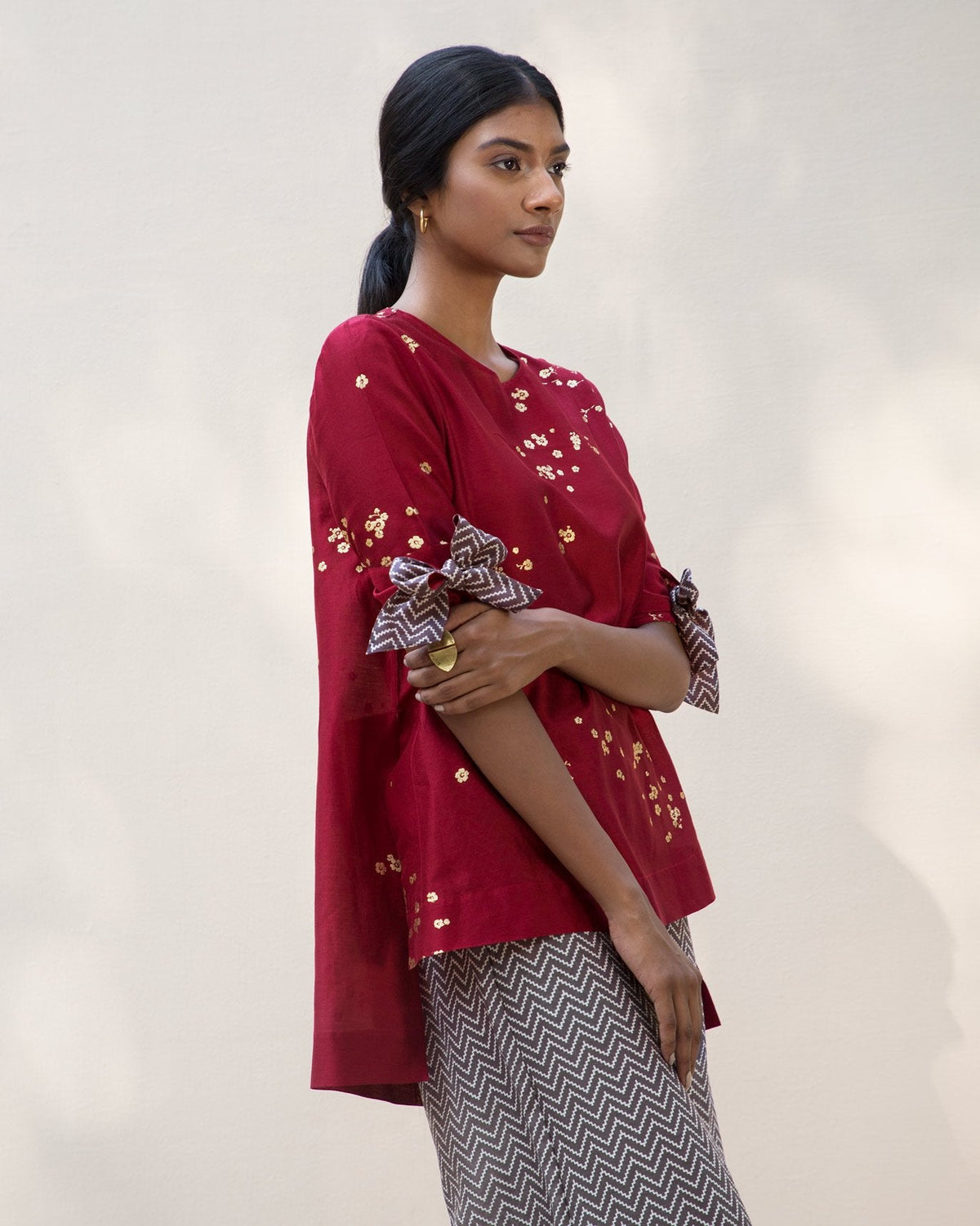 Side view of a red Side High Slit Top worn by a person.