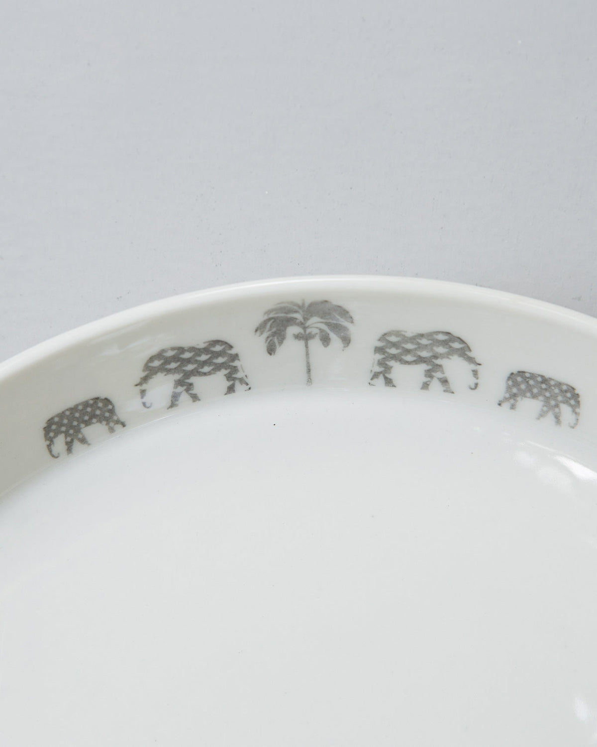 Close-up of Colombo Pasta Plate rim showing grey elephant and palm motifs.