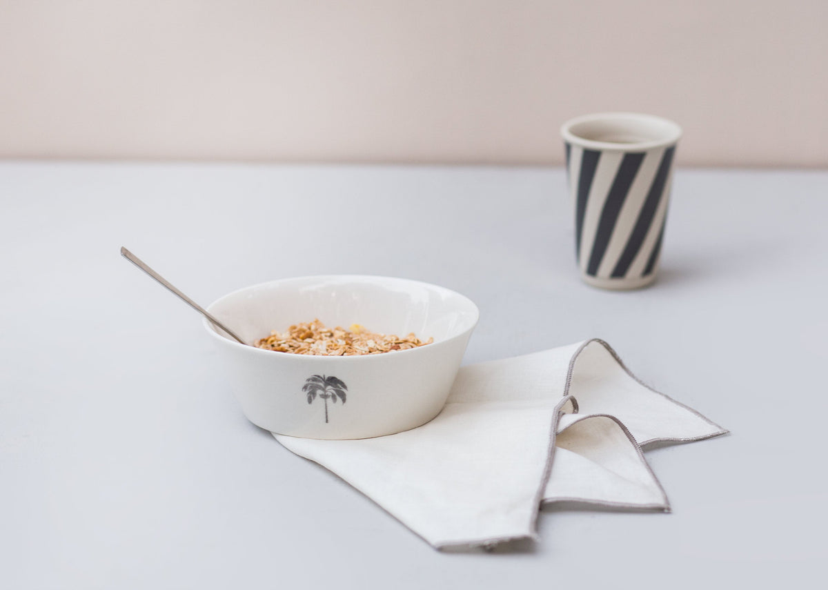 Colombo Cereal bowl filled with cereal, with a spoon and a napkin beside it.