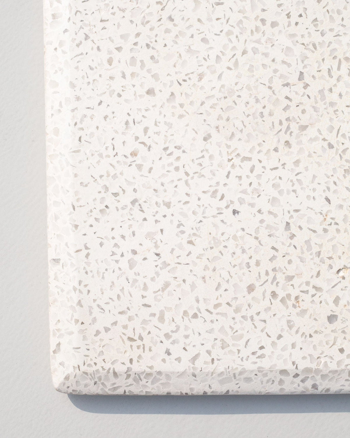 Close-up of Colombo Rectangle Cheese showing its white speckled surface and edge.