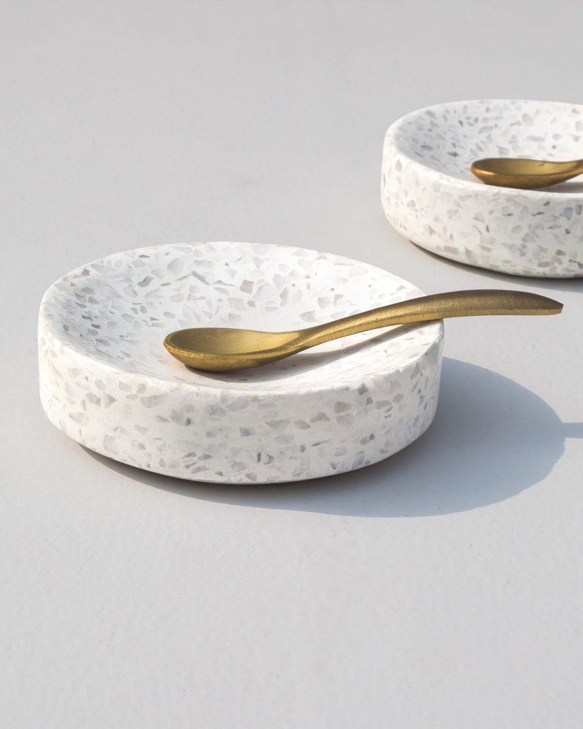Colombo Pinch Pot with Spoon shown as a pair, with a gold spoon resting in the front dish.