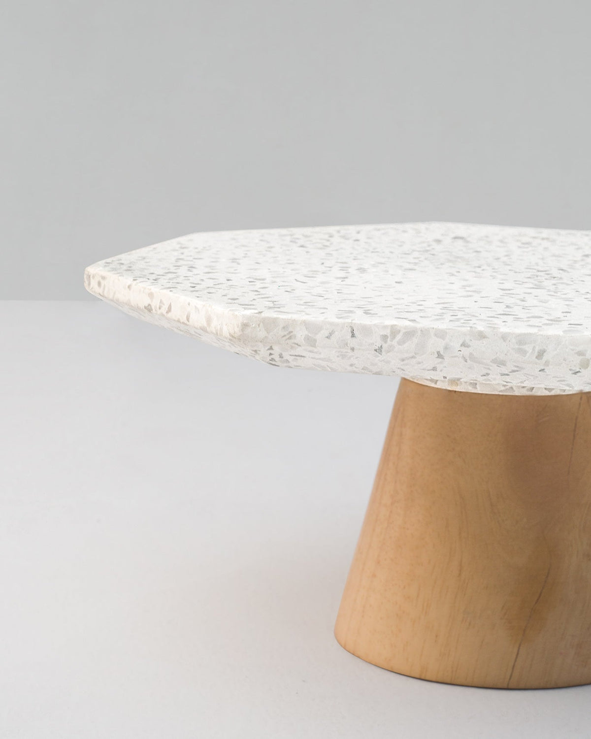 Close-up of a Colombo Cake Stand - Large showing its speckled edge and wooden base.