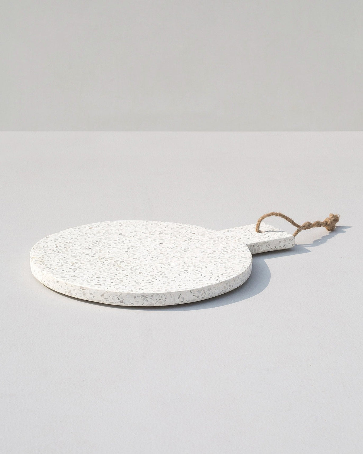 Side view of Colombo Round Cheese Board with its handle and cord loop.
