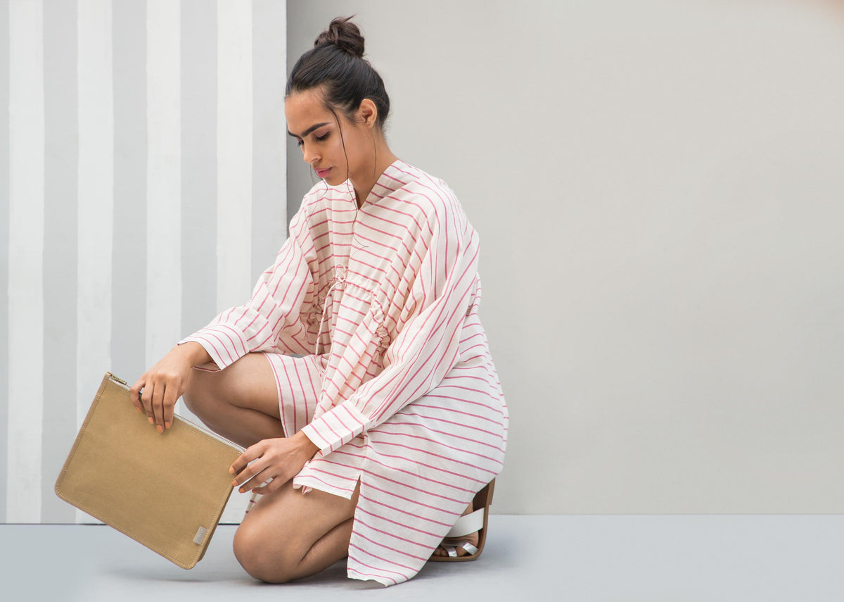 Person holding a brown Paper Pouch.