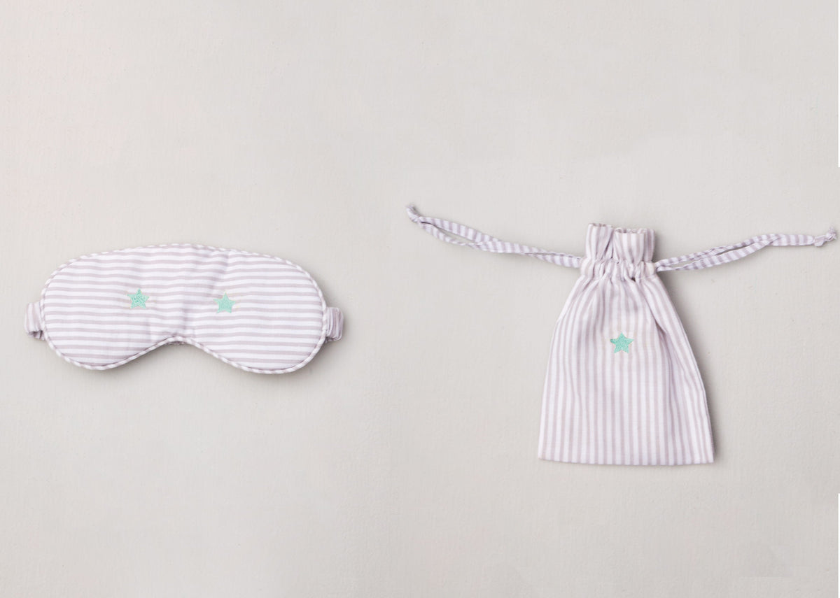 Star Snooze Eye Mask and pouch laid side by side, with mint stars.