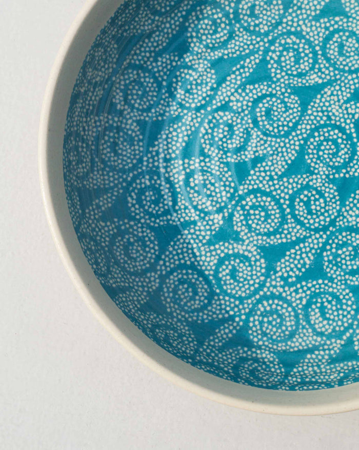 Close-up of the Dot Shallow Bowl showing its white dotted swirl pattern.