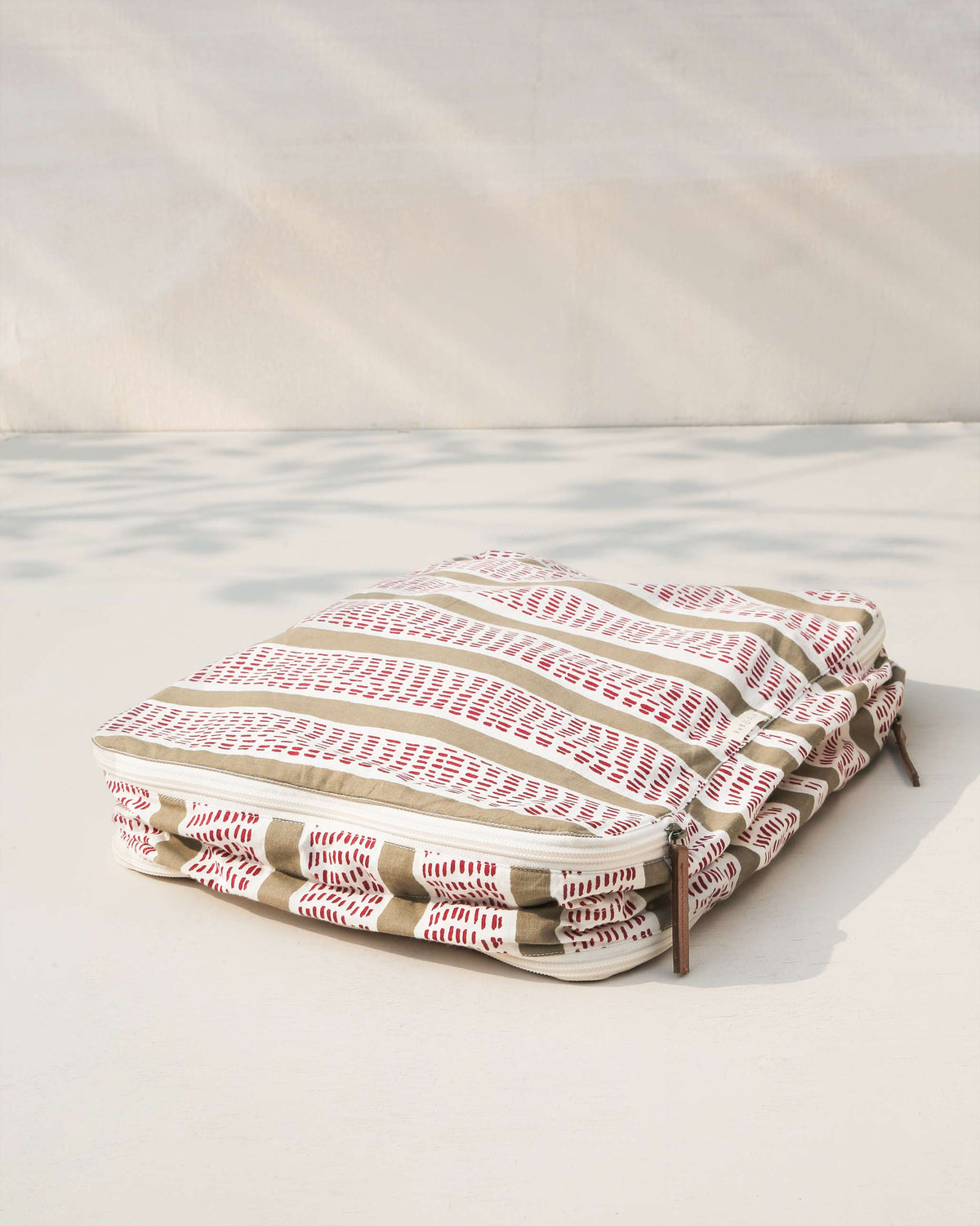 Sort Sack at an angle, showing olive and white stripes with red dashes.