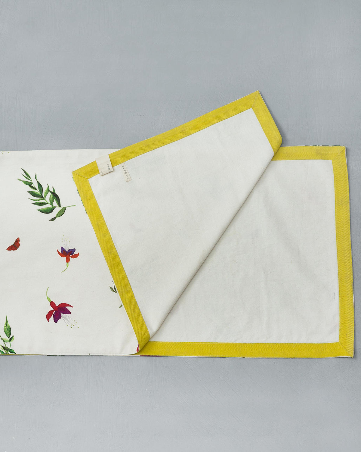 Back of Botanical Runner showing a plain cream side with yellow edging.
