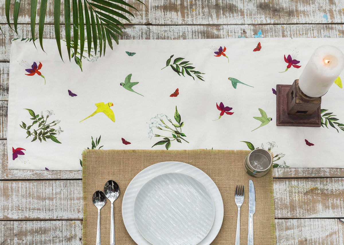 Botanical Runner laid across a wooden table, showing birds and leaves.