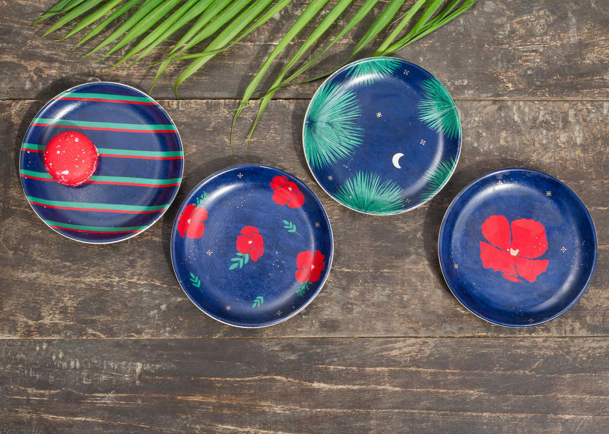 Overhead view of Wonderland Tea Plates on a wooden table, with palm leaves above.