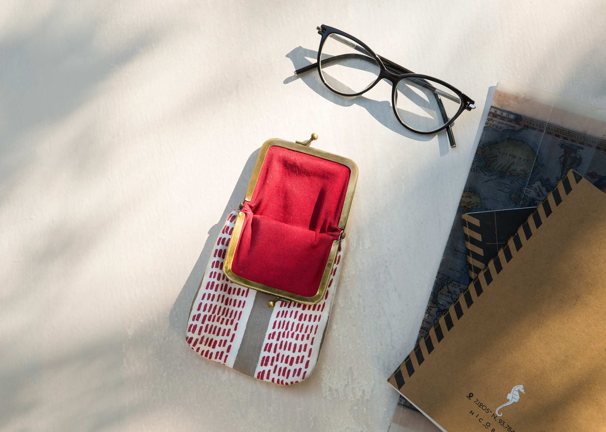 Hana Mushru Spec Case beside a pair of glasses on a light surface.
