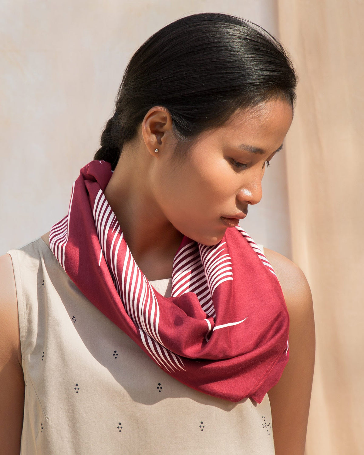 Person wearing a red Illustration Scarf looped at the neck.