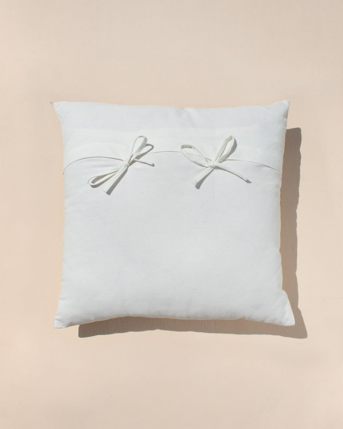 Back of the Dot Cushion Cover, plain white with two bow ties.