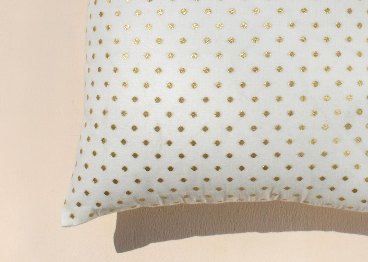 Close-up of the Dot Cushion Cover's gold dot pattern at one corner.