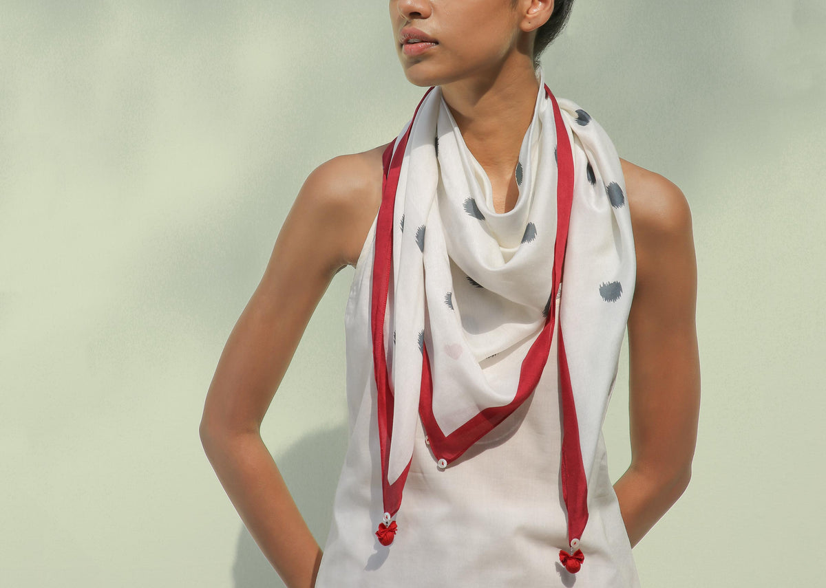 Person wearing a Dot Scarf with its red-edged ends hanging loose.