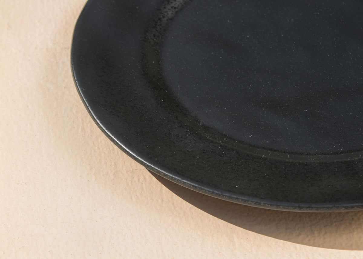Close-up of the rim of a Desert Dusk Dinner Plate in black.
