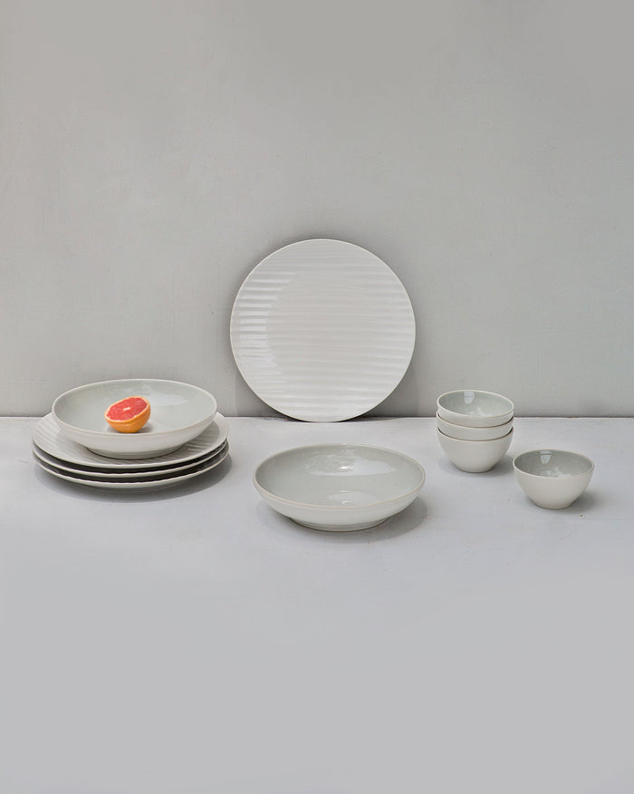 Desert Dune Starter Kit of ridged white plates and bowls arranged together.