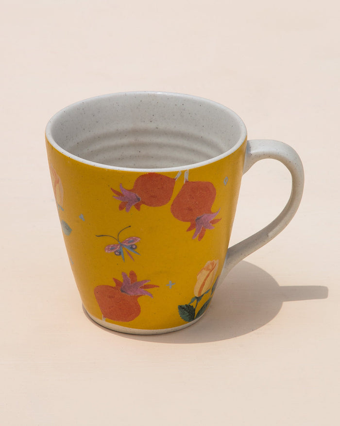 Anar Bud Mug in yellow with orange fruit and flower prints.