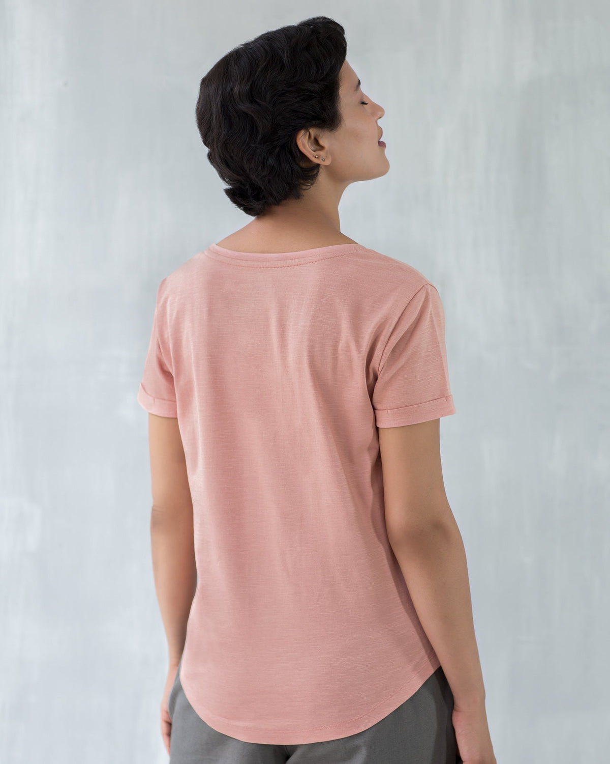 Back of a pink Basic T-shirt worn by a person.
