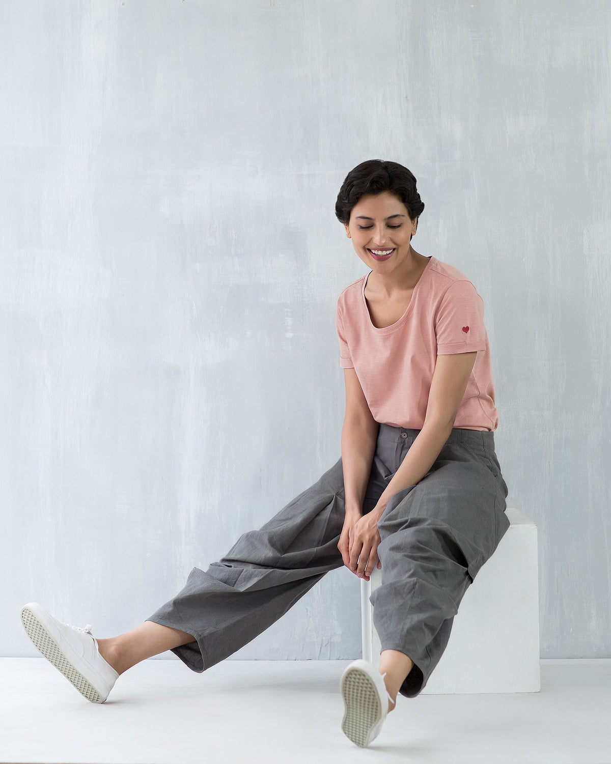 Person wearing a pink Basic T-shirt, seated.