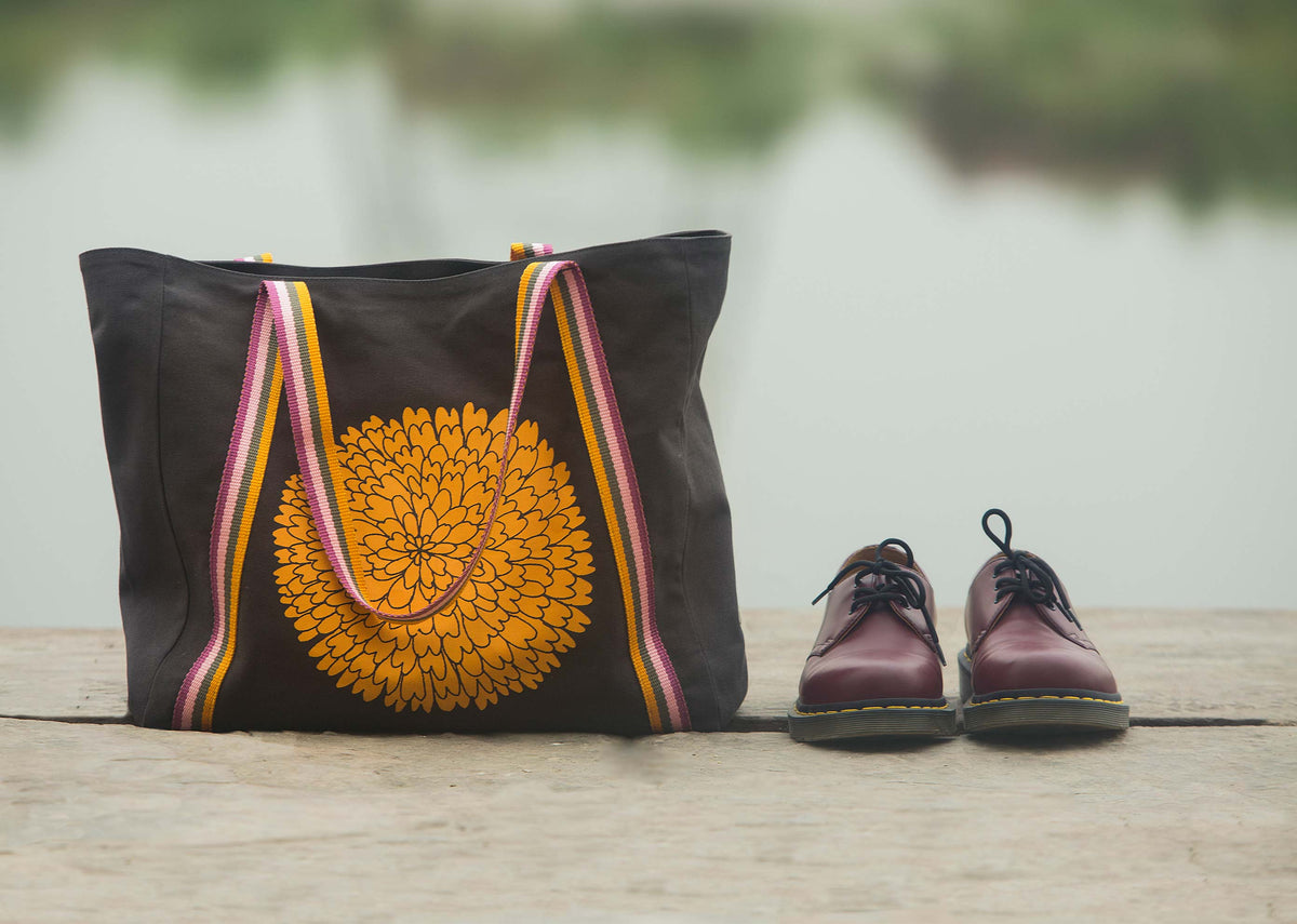 Marigold Tote standing on a wooden ledge with its marigold print.