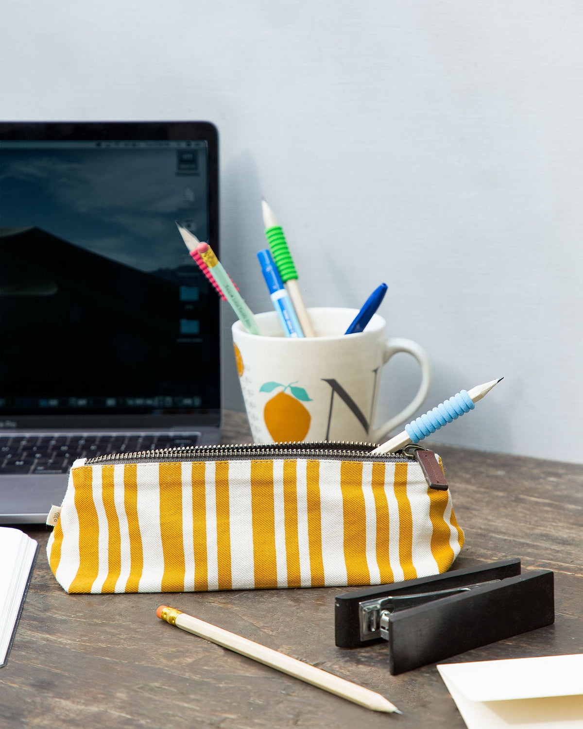 Oasis make-up pouch resting on a wooden desk.