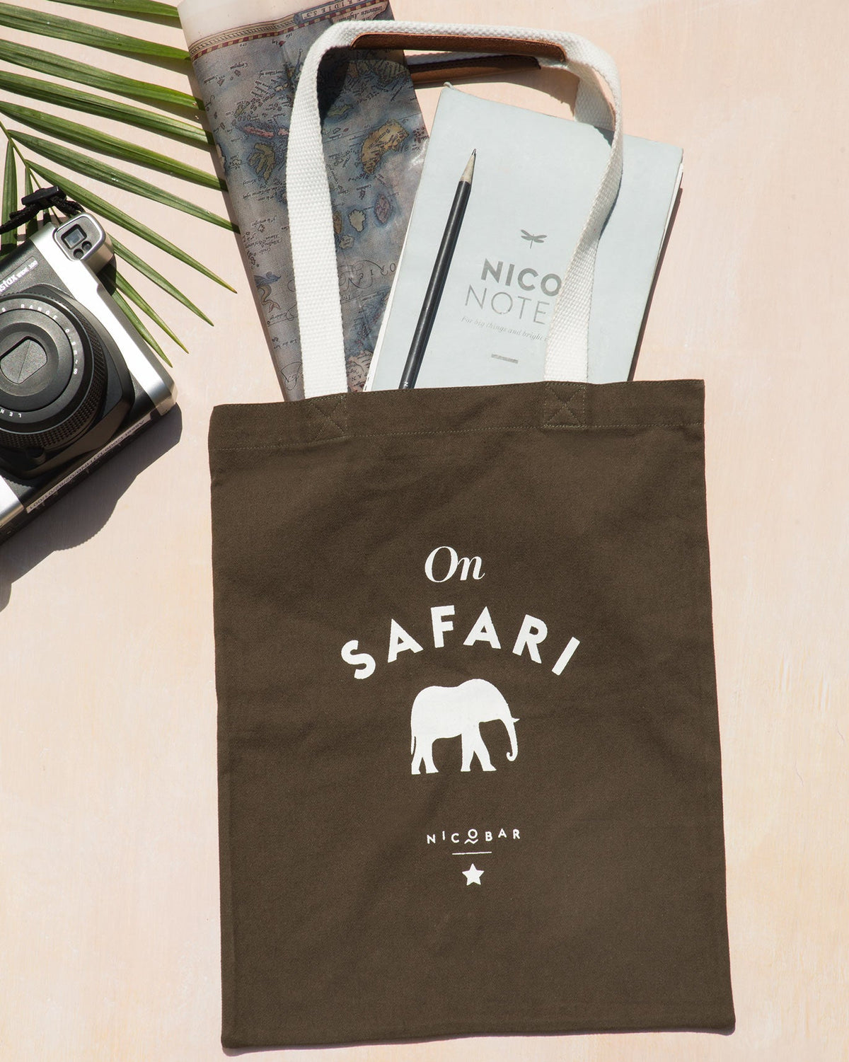 On Safari tote laid flat, with its cream handles raised and the elephant graphic visible.