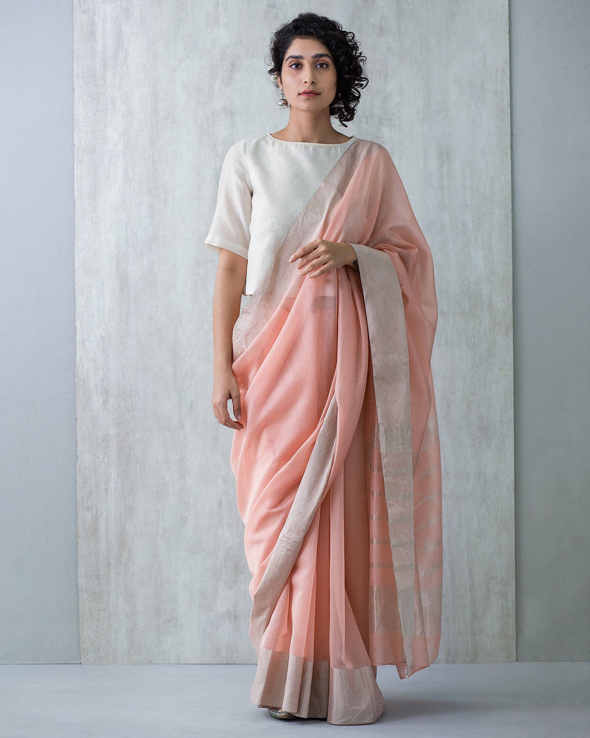 Full-length view of a pink Serai Sari with a cream blouse worn by a person.