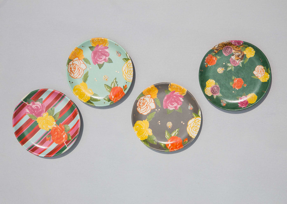 Overhead view of four Serai Tea Plates in floral and striped prints.