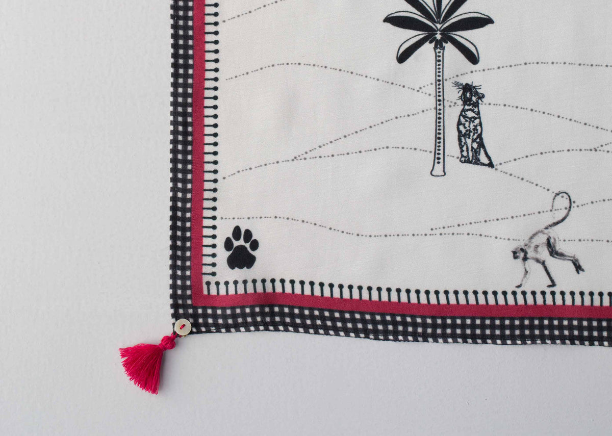 Close-up of a Jawai scarf corner with palm tree and paw print motifs.