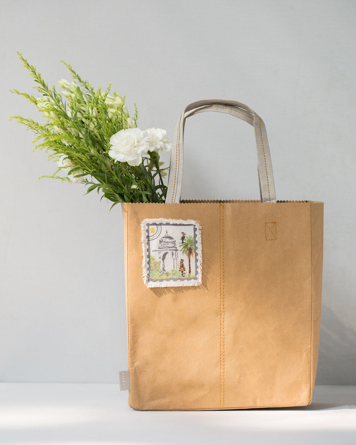 Sher Bagh Paper Tote with white flowers in it.