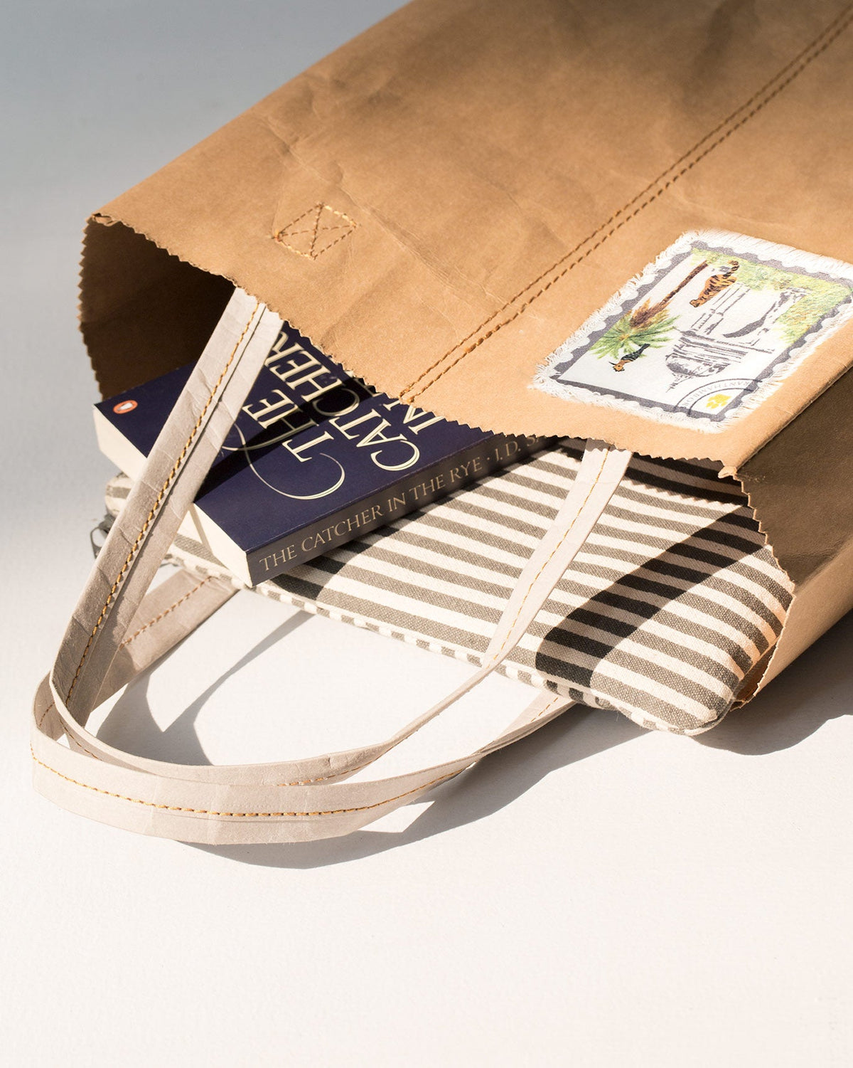 Sher Bagh Paper Tote open, with a book and striped pouch inside.