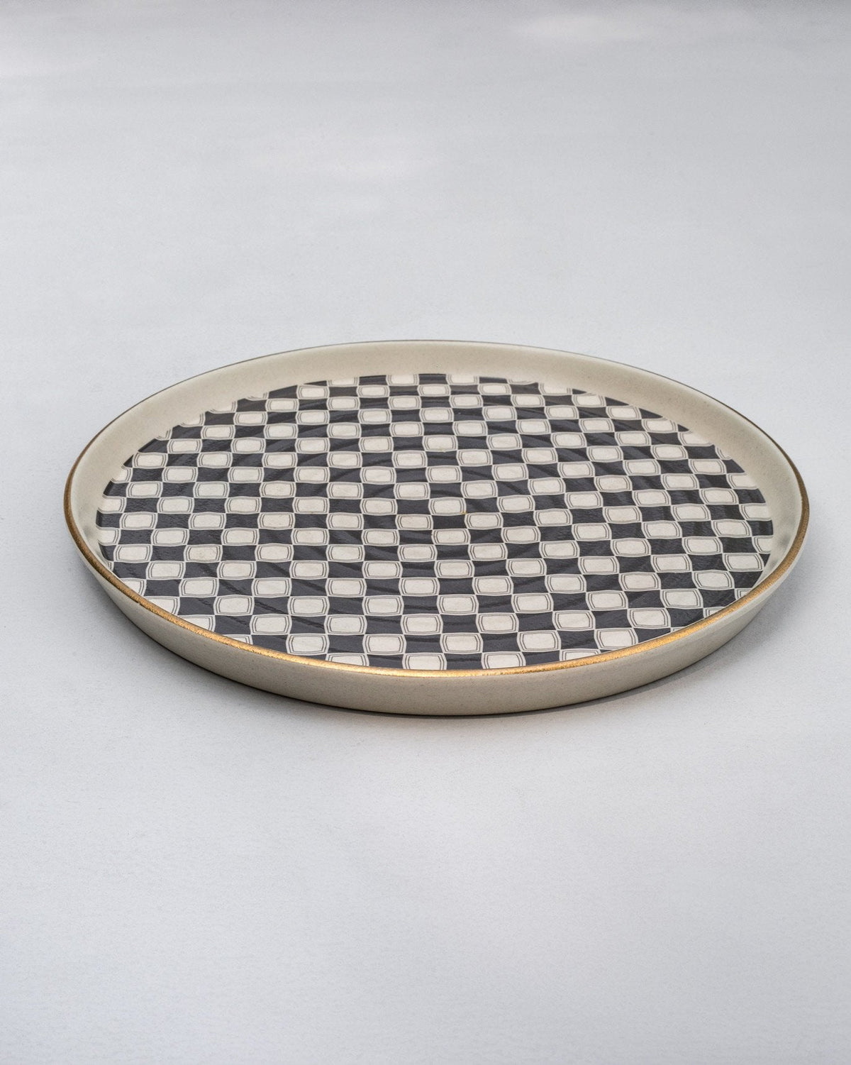 Fez Round Platter at an angle, showing its checked surface and gold rim.