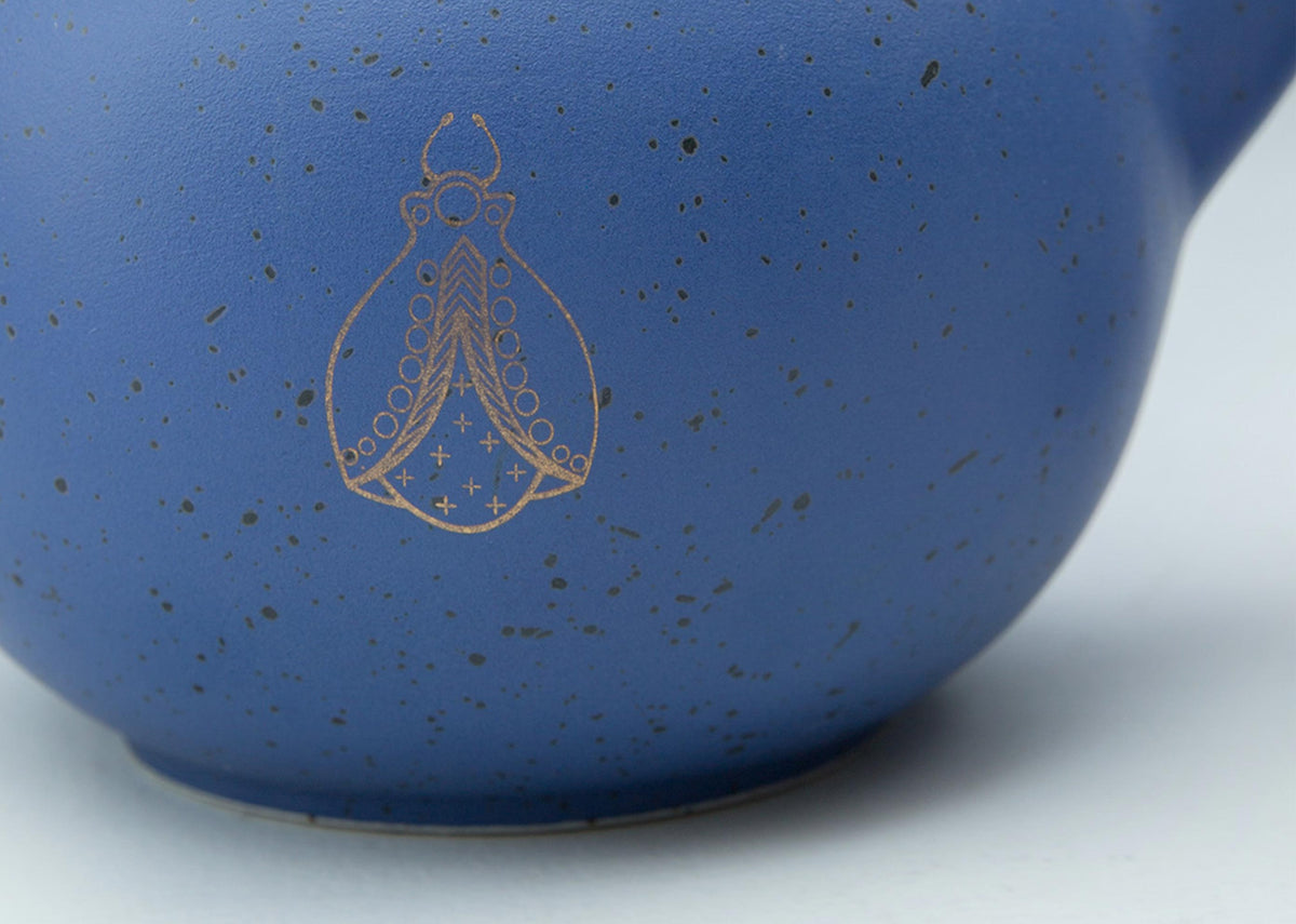 Close-up of the blue Bug Teapot body showing a gold bug motif.