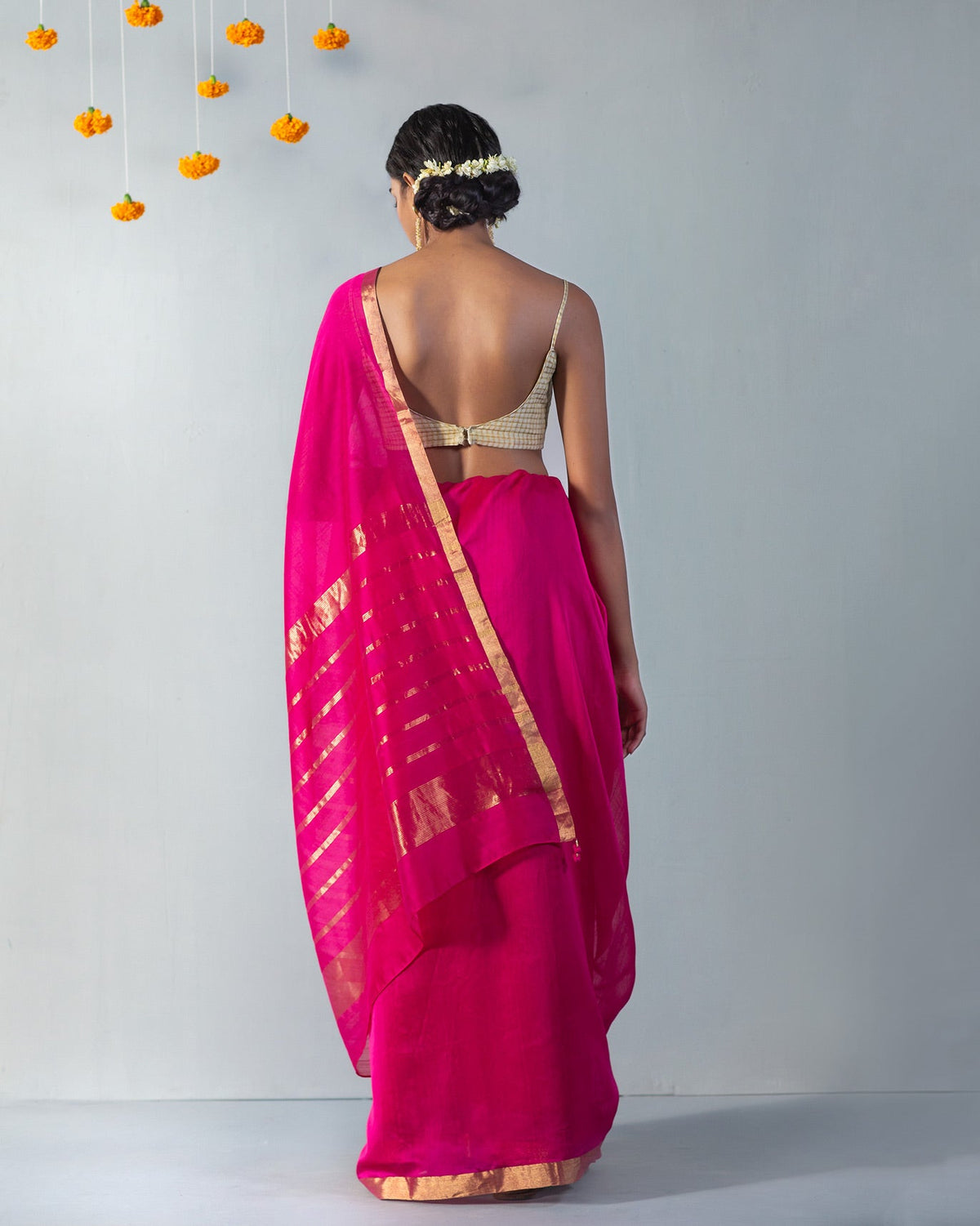 Back of Kimsuka Sari worn by a person, showing the gold border.