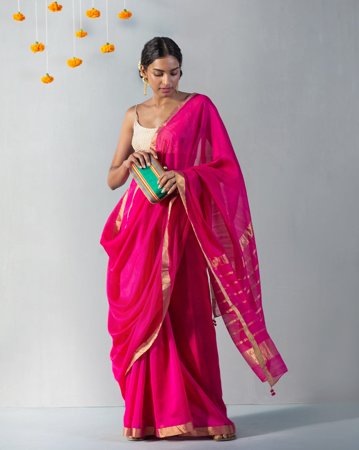 Person wearing Kimsuka Sari with its gold-striped end draped across the front.