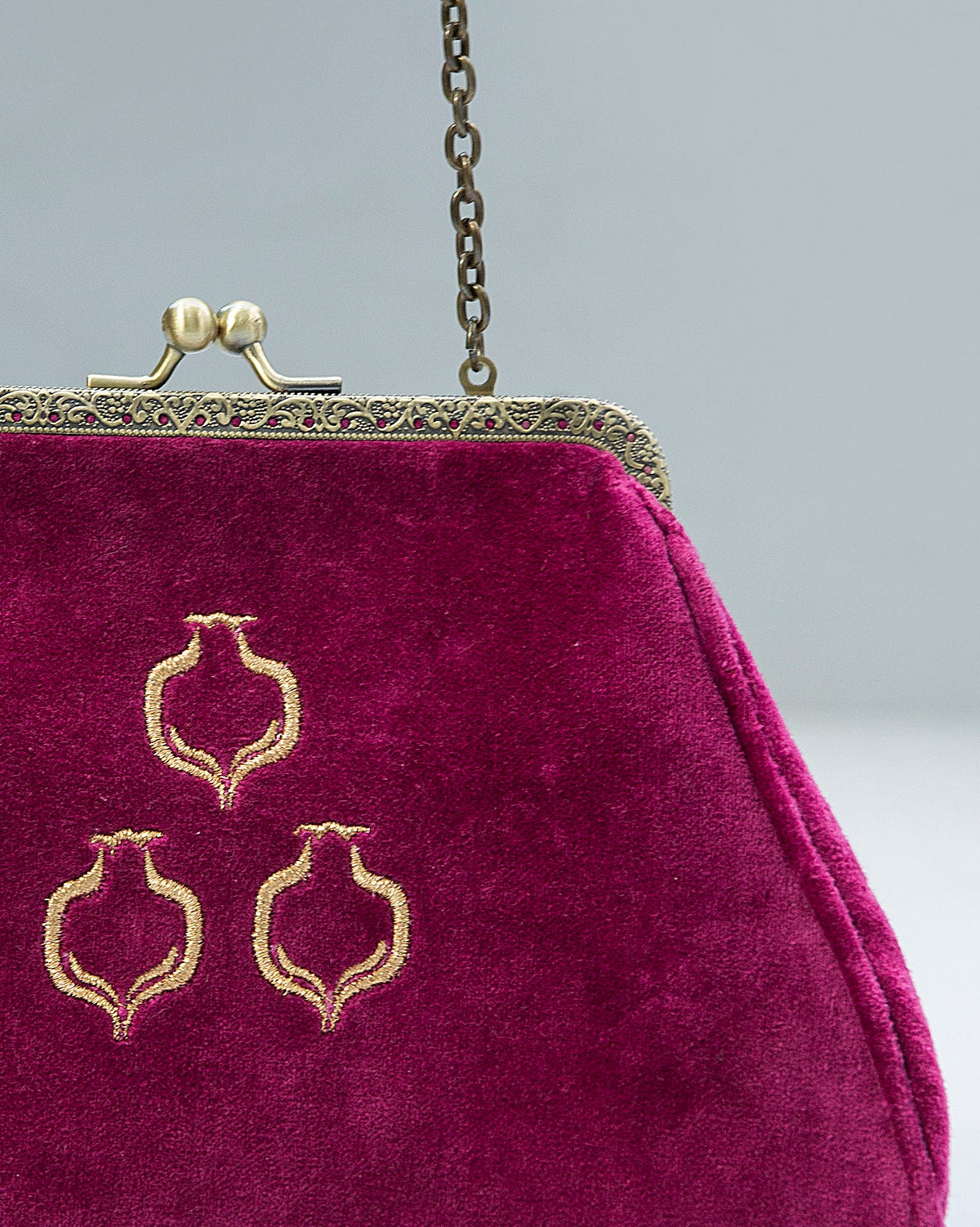 Close-up of the Romani Clutch showing its gold embroidered motifs and frame clasp.