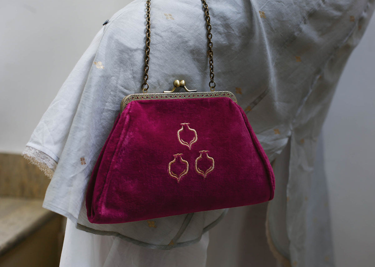 Person carrying the Romani Clutch by its chain strap.