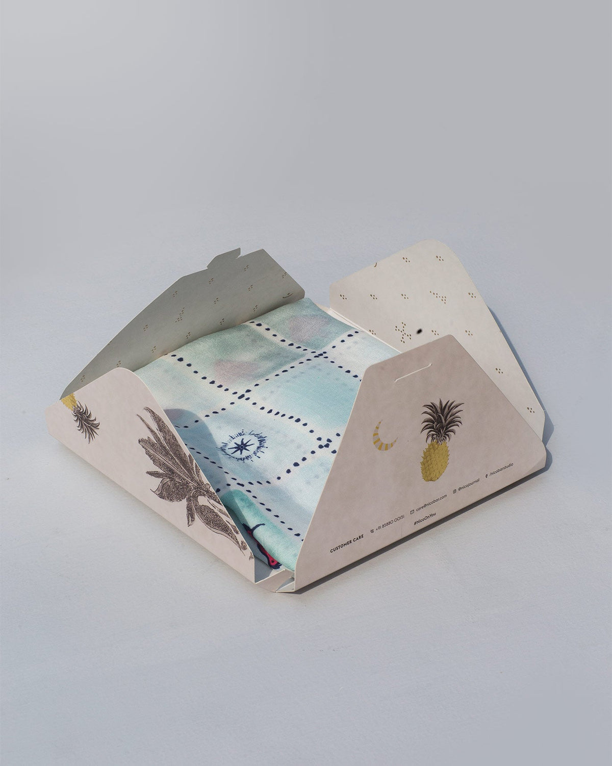 Stamp Scarf partly unfolded inside its printed gift box.