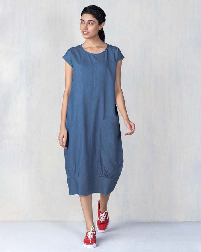 Person wearing a blue Shibui Dress with a side patch pocket.