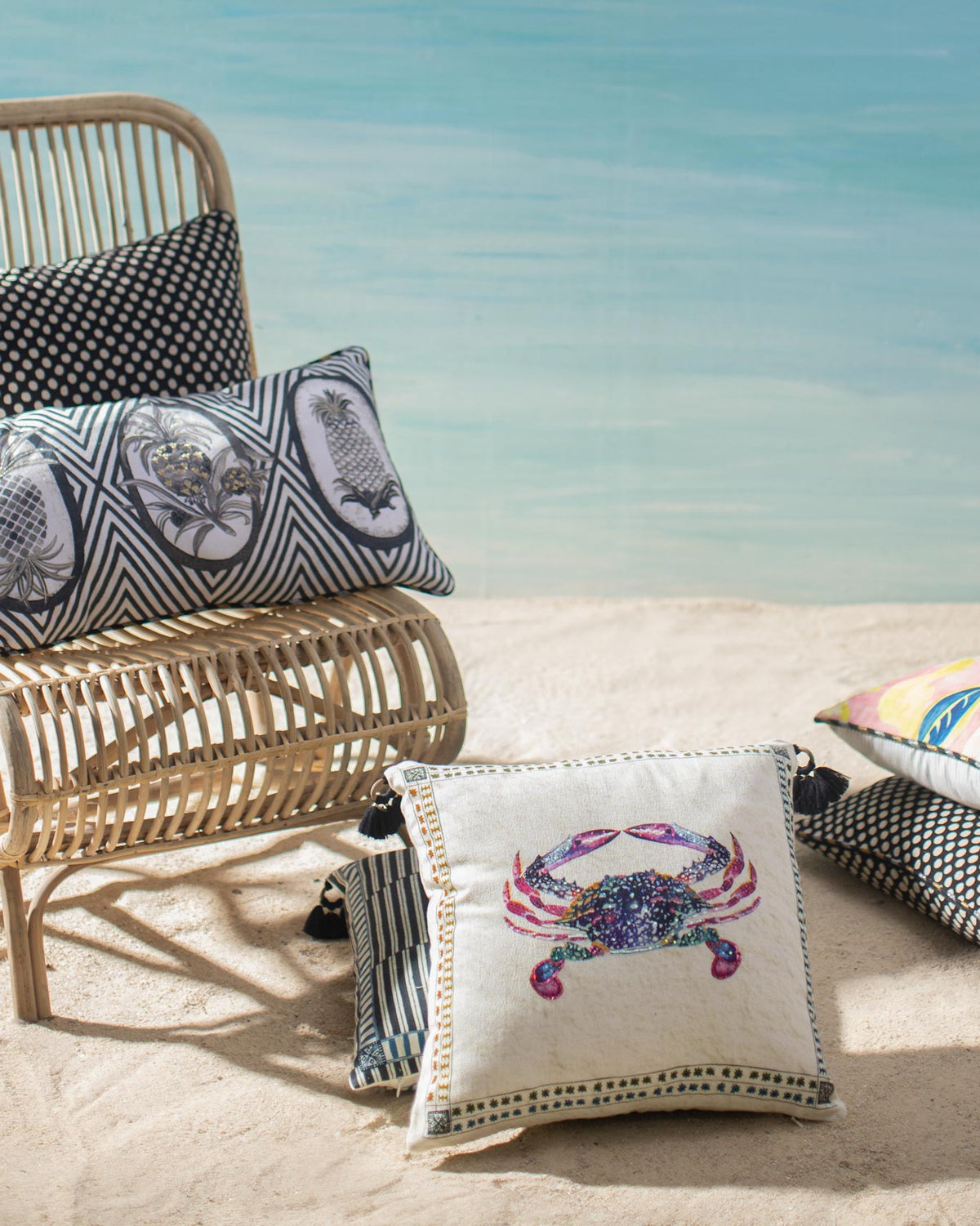 Crab Cushion Cover with a multicoloured crab, shown on sand.