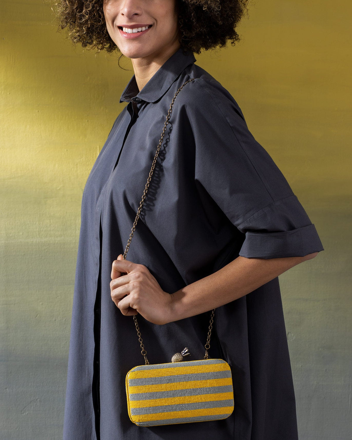 Person carrying the Ananas clutch by its chain strap.